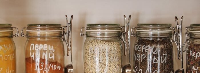 Variety of Spices in Glass Jars on Wooden Shelves